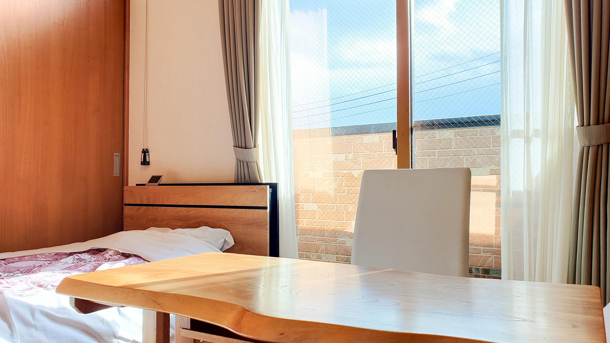 #喫煙ツイン　大きな窓から差し込む朝日で穏やかな空気感を感じられるお部屋です。