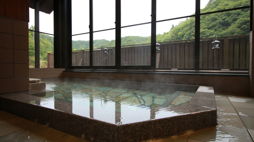 #美肌の湯　大きな窓が開放的な大浴場。季節の移ろいを感じながらお寛ぎください。　