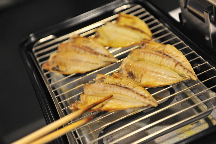 共用キッチンで干物を焼く