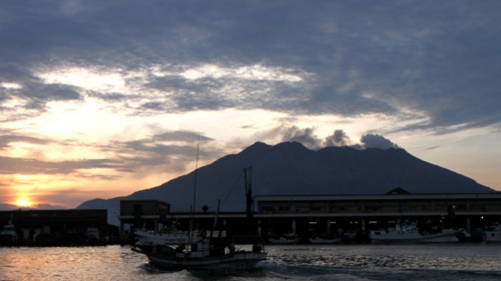 夏の日の出、桜島と魚市場（鹿児島市中央卸売市場魚類市場）