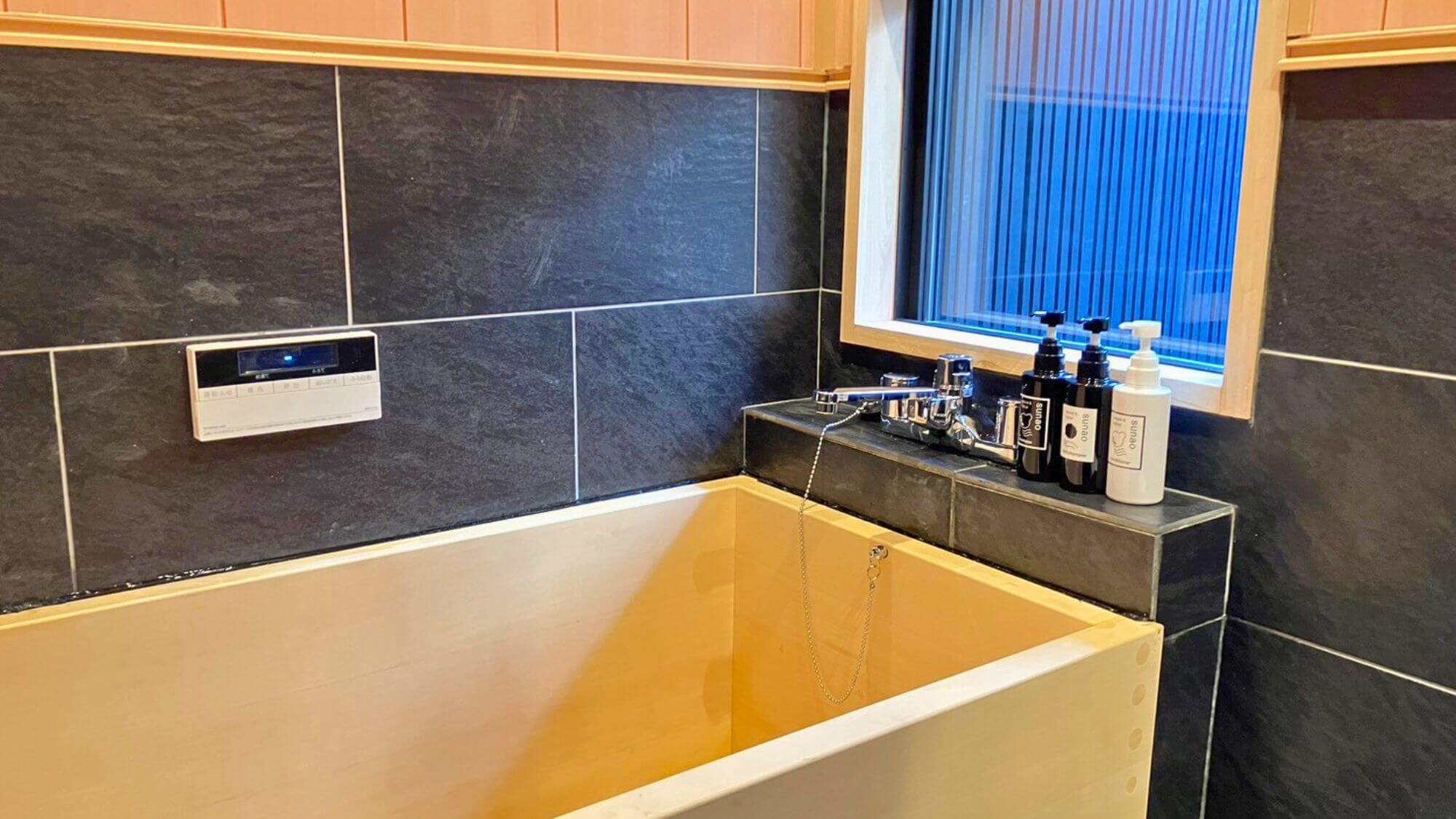 【浴室】檜の香りが心地よい檜風呂。窓からは坪庭の景色が。