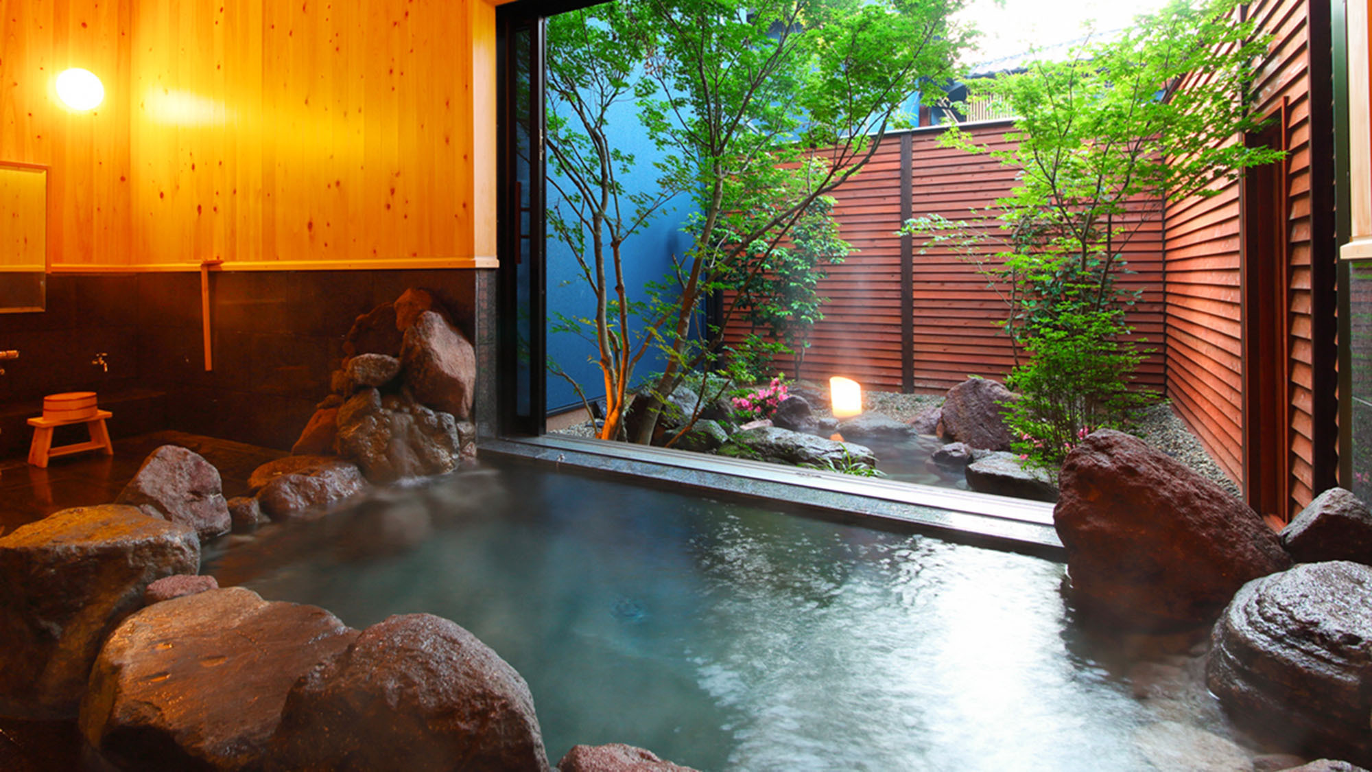・【文(ぶん)】檜の壁がやさしく香る内湯には個性豊かな石々で組まれた赴き深い岩風呂。