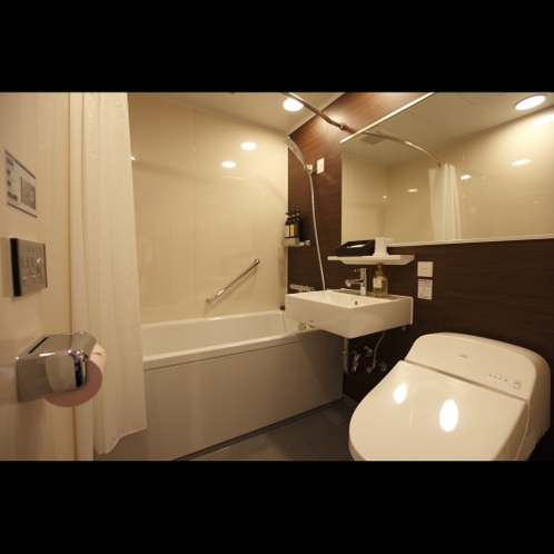 モダンシングルルームは140cm×180cmとゆったりしたワイドミラー付バスルーム（トイレ洗面一体）