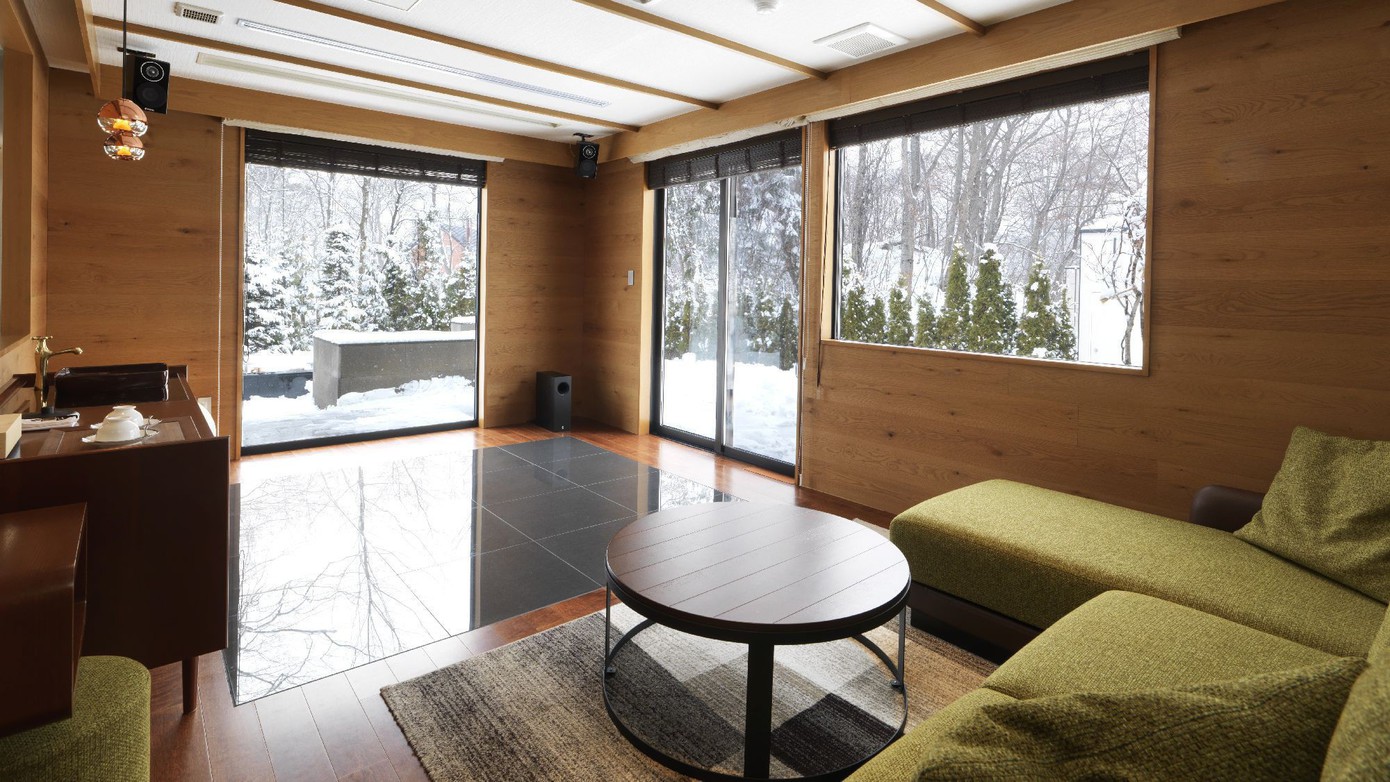 ◆スパリビング付ツインルーム（冬）／大きなソファで寛げるリビング。隣には温泉スパルームが（客室一例）