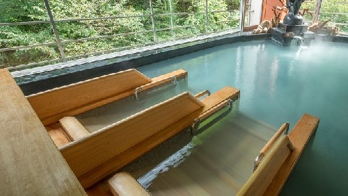 【大浴場】「鳳山の湯」の中にある寝湯。大きな窓から自然を眺めながらゆっくりと湯浴みをお愉しみ下さい。