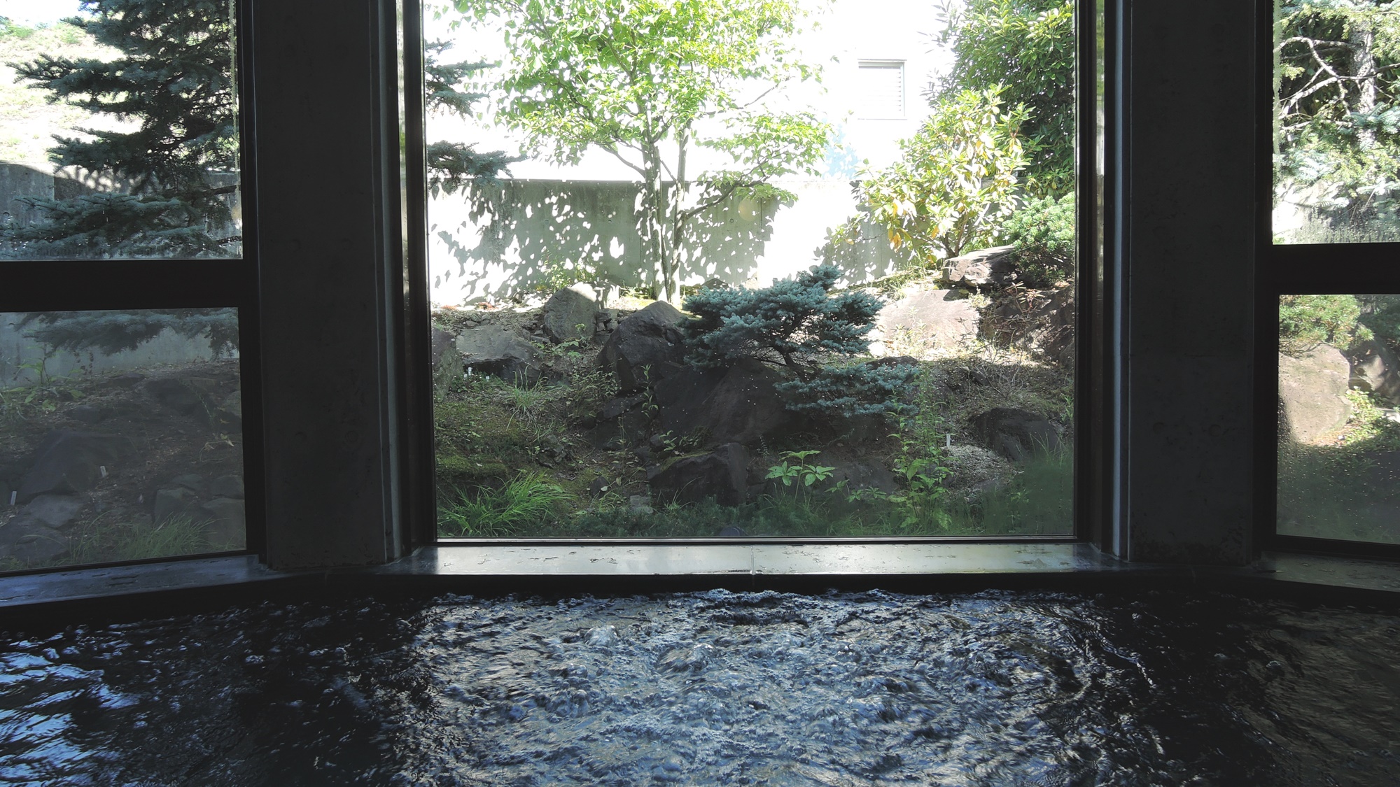 *大浴場ハーブ風呂／窓の外には季節の花が咲くロックガーデンが眺められます。