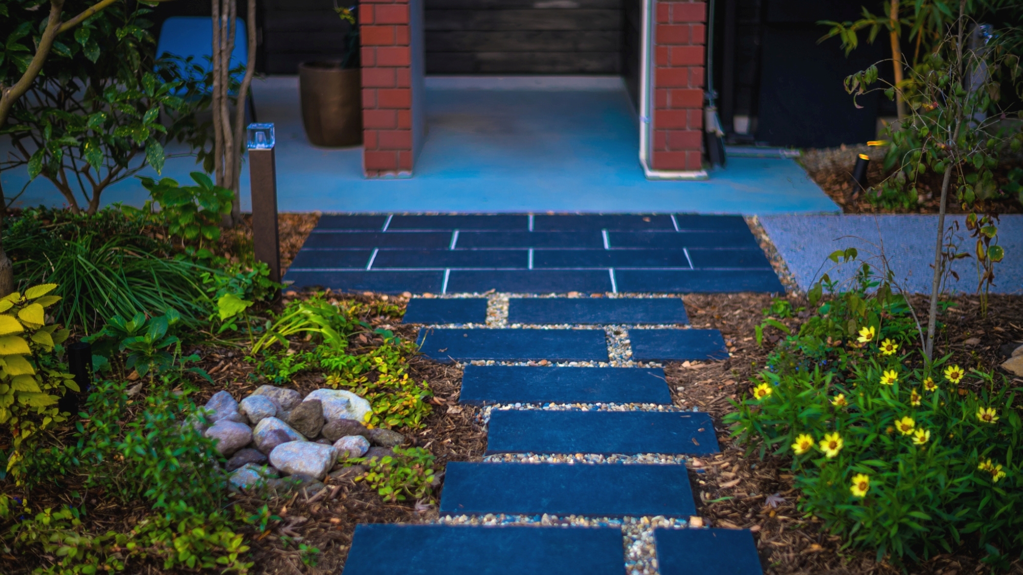 季節の草花と石畳が迎えるアプローチ