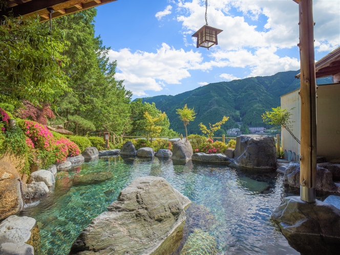 【露天風呂　飛山之湯】自然に囲まれた当館の露天風呂。解放感あふれる景色と共に楽しむ。