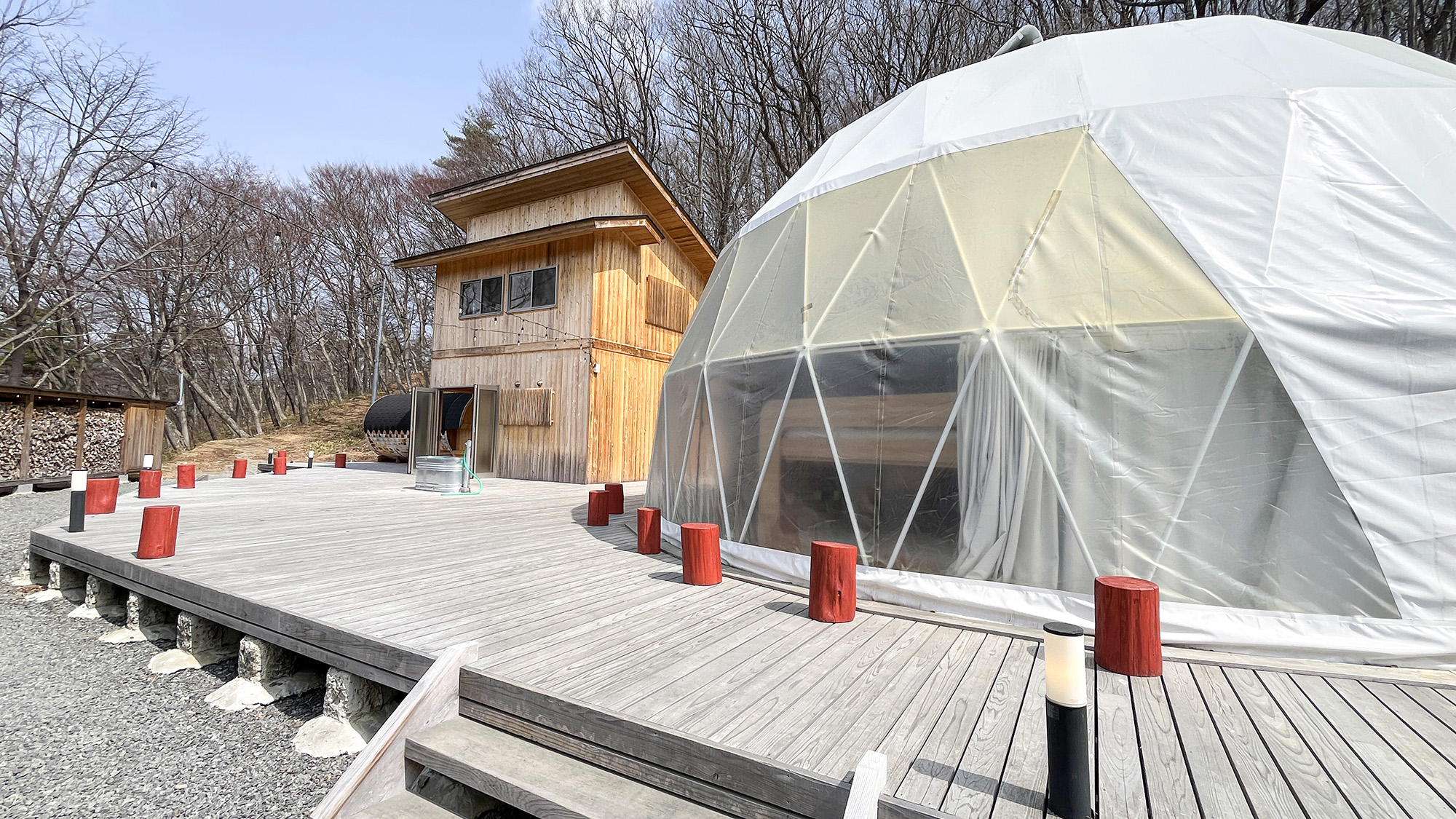 #響きのサウナグランピング　ウッドデッキで繋がるドームとコテージ棟。