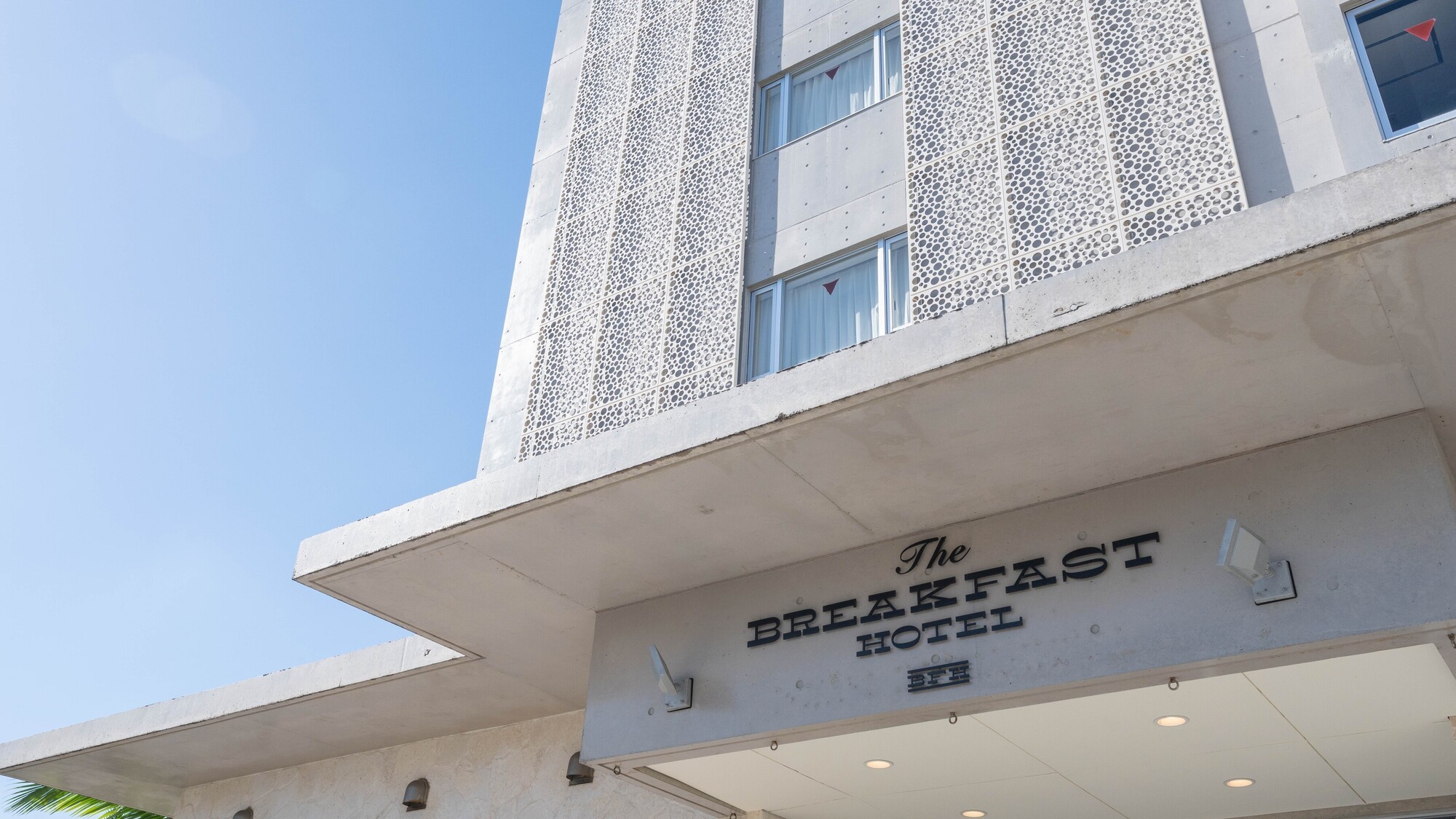 ホテル棟：コンクリートの質感が映えるモダンな外観