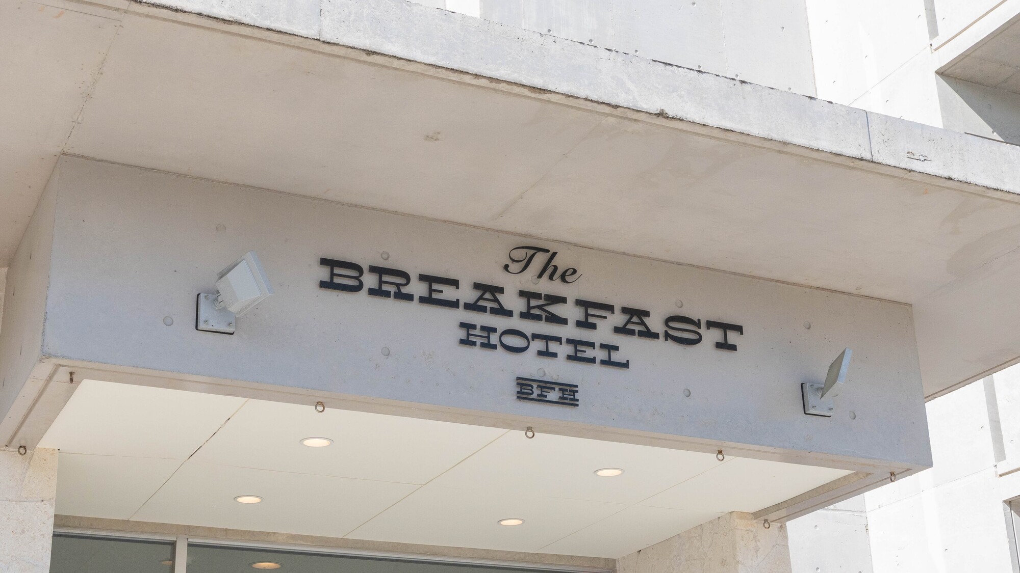 ホテル棟：ホテルのロゴが目印の入口で皆さまをお迎えします