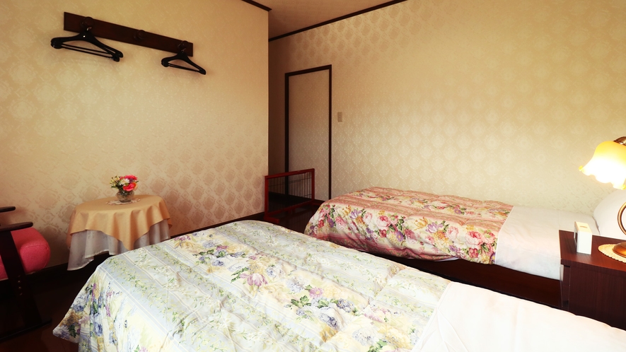 【客室一例】落ち着いた雰囲気のベッドルーム。