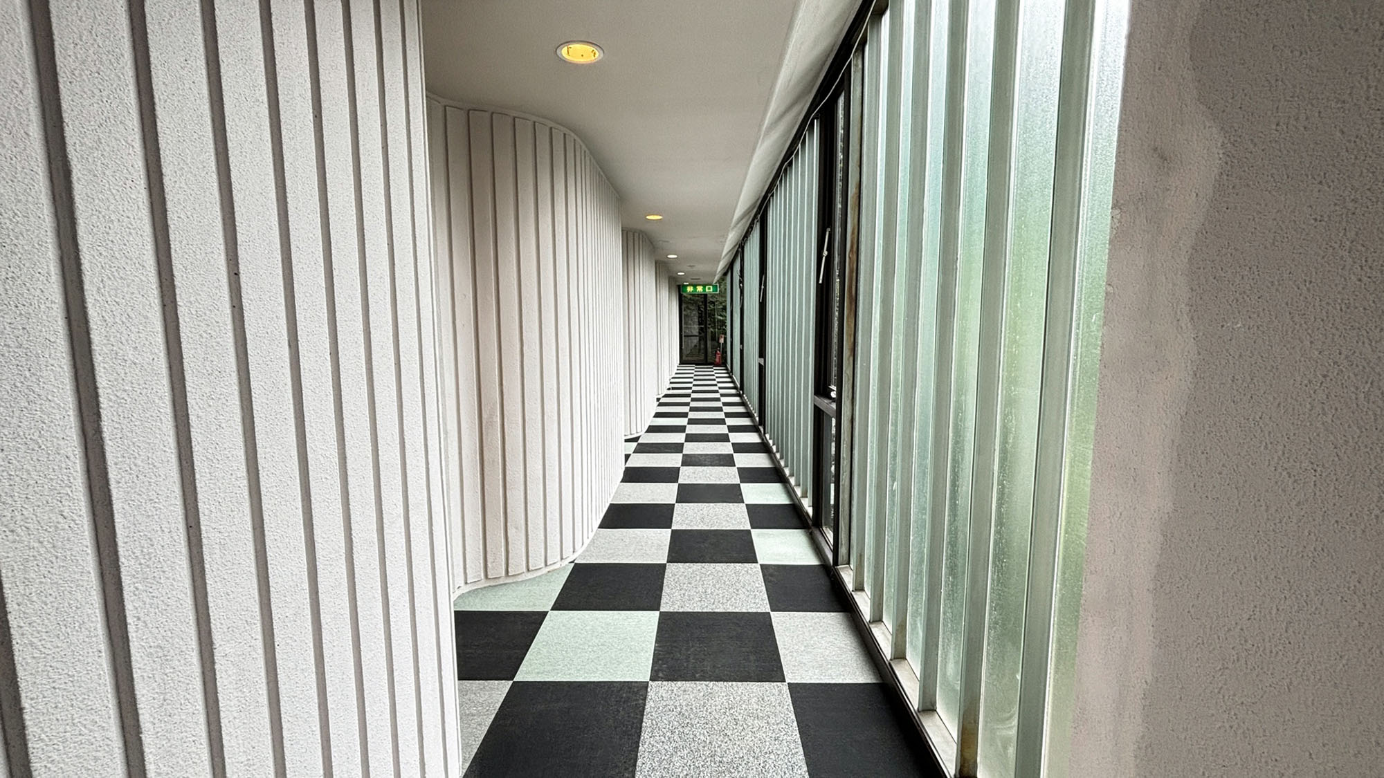 ・【宿泊棟】市松模様の廊下に曲面と縦線の壁面。コントラストが美しく個性的です