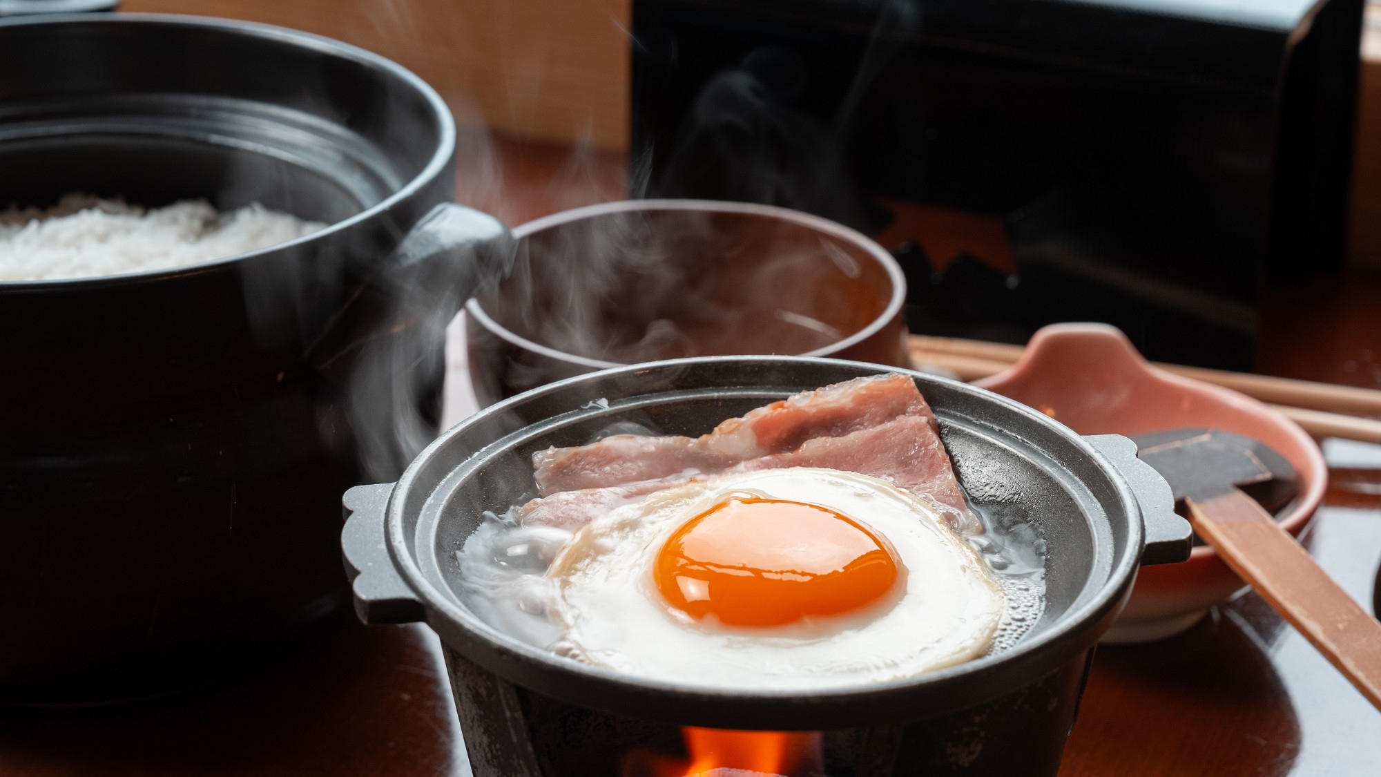 ■朝食一例｜陶板とベーコンをご用意。生卵を目玉焼きにするのもおすすめ。お好みの食べ方で。