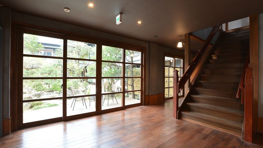 食事処前室です。一面が窓になっており、木造建築ならではの味がある階段がございます。