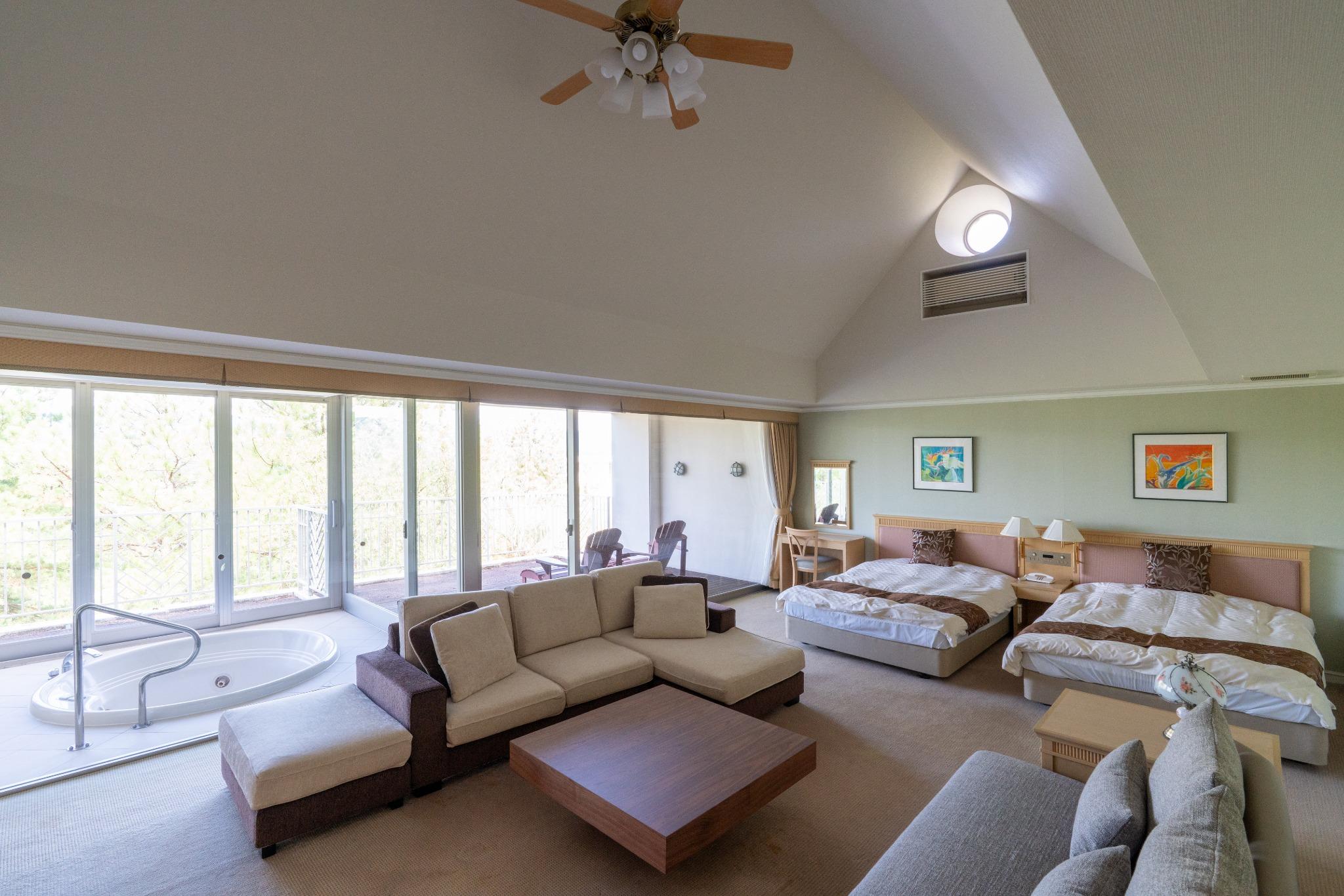 ココパリゾートクラブのキングスパレスは、天井の高い開放的な空間と大きな窓が特徴です。室内にはゆったりと寛げるソファスペースがあり、専用のジャグジーから緑豊かな景色を眺められます。４つのベッドがある洋室タイプで、カップルやご夫婦の記念日旅行にもおすすめ。三重県でリゾート感あふれる滞在を楽しみたい方に最適の客室です。非日常を感じる贅沢なひとときをお過ごしいただけます。