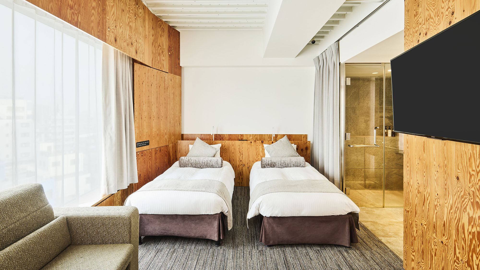 デラックスツイン｜東京スカイツリー&reg;を望む大きな窓から光が差し込むツインルーム。