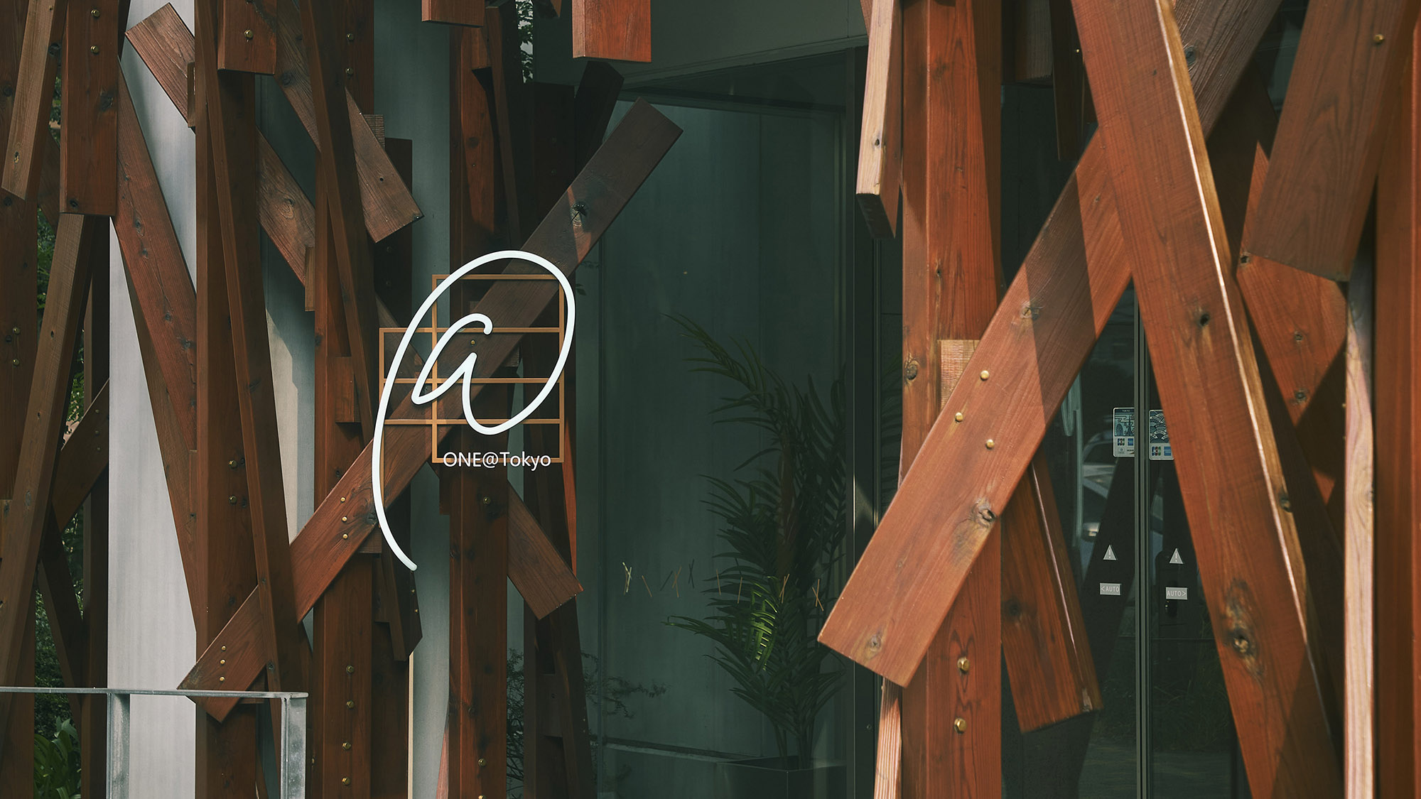 ホテルエントランス（昼）｜伝統的な木組みと無機質な工業素材を融合させたユニークなデザインが特徴。