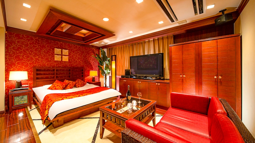 ・【スタンダード　一例】重厚感あるウッディ調の家具と赤色がマッチした大人気分のお部屋です。