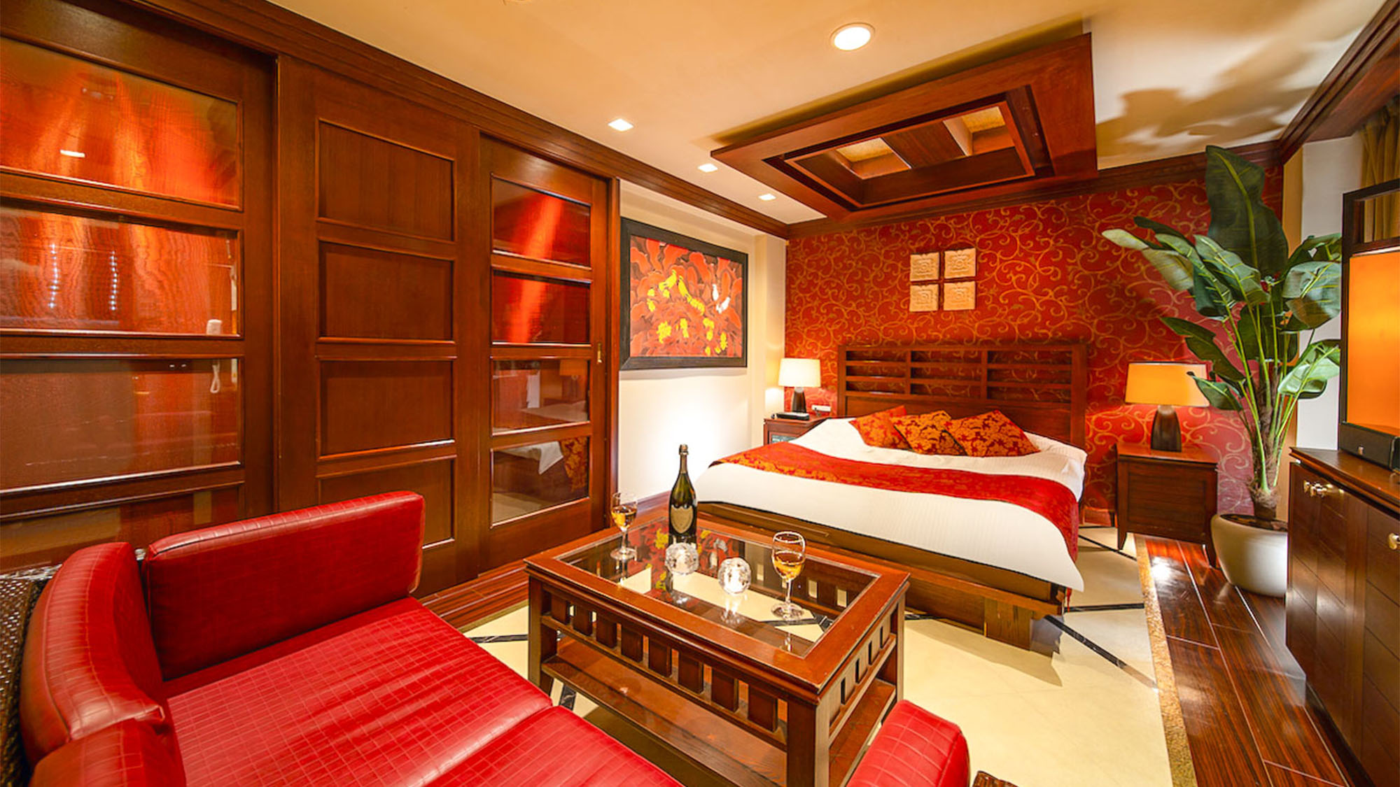 ・【スタンダード　一例】重厚感あるウッディ調の家具と赤色がマッチした大人気分のお部屋です。