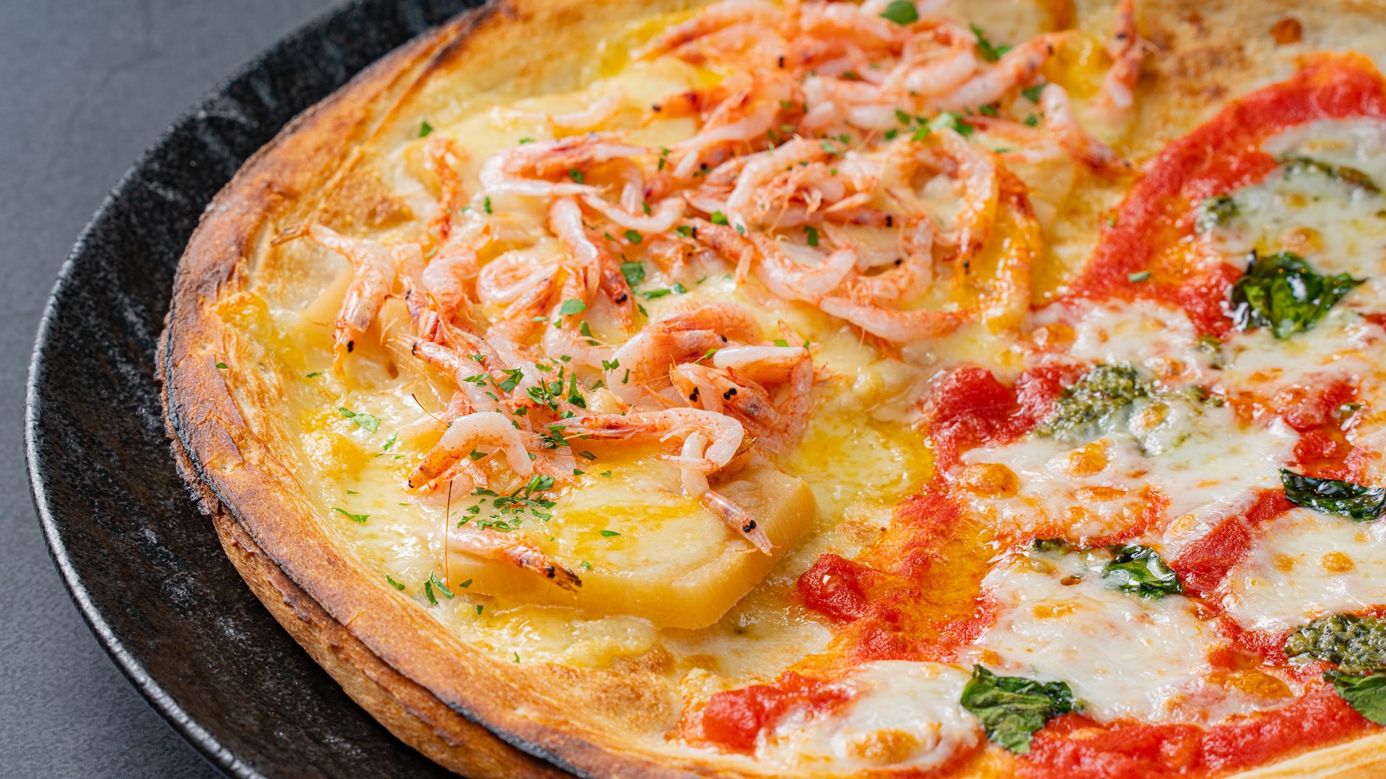 *季節のピッツァ一例（５月）／彩りが春らしい&ldquo;ピッツァマルゲリータと桜海老と筍のハーフ＆ハーフ&rdquo;