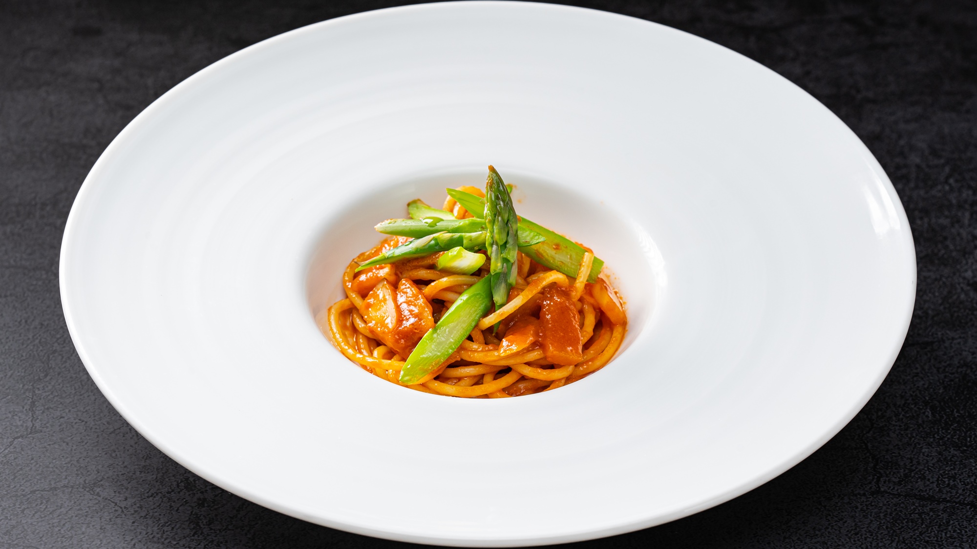 *季節のパスタ一例（５月）／新ごぼうとアスパラのトマトクリームソース。緑と赤のコントラストが美しい。