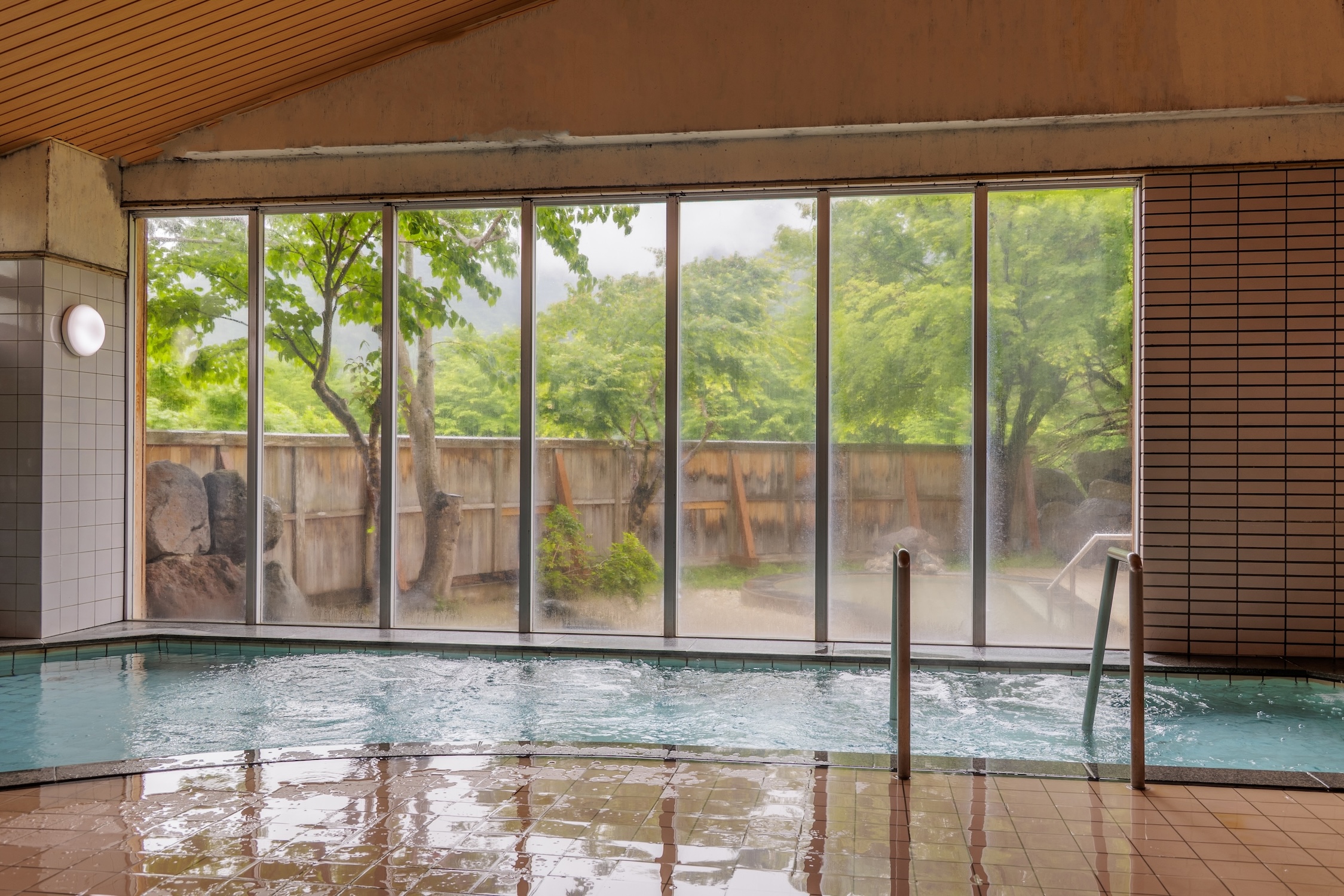 大きな窓ガラスからは只見の美しい自然を眺められる大浴場。たっぷりと温泉が溢れる