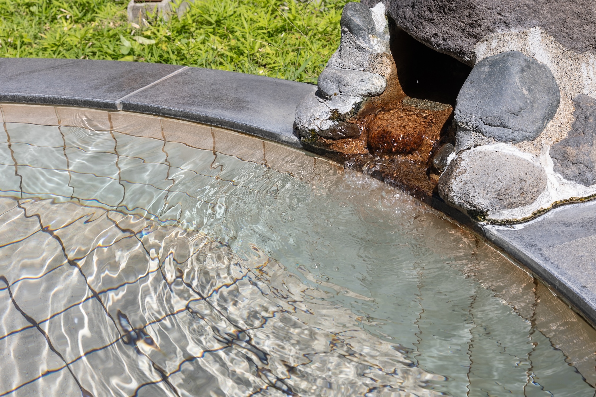 自家源泉からこんこんと沸く温泉が溢れる自然に包まれた気分になる露天風呂
