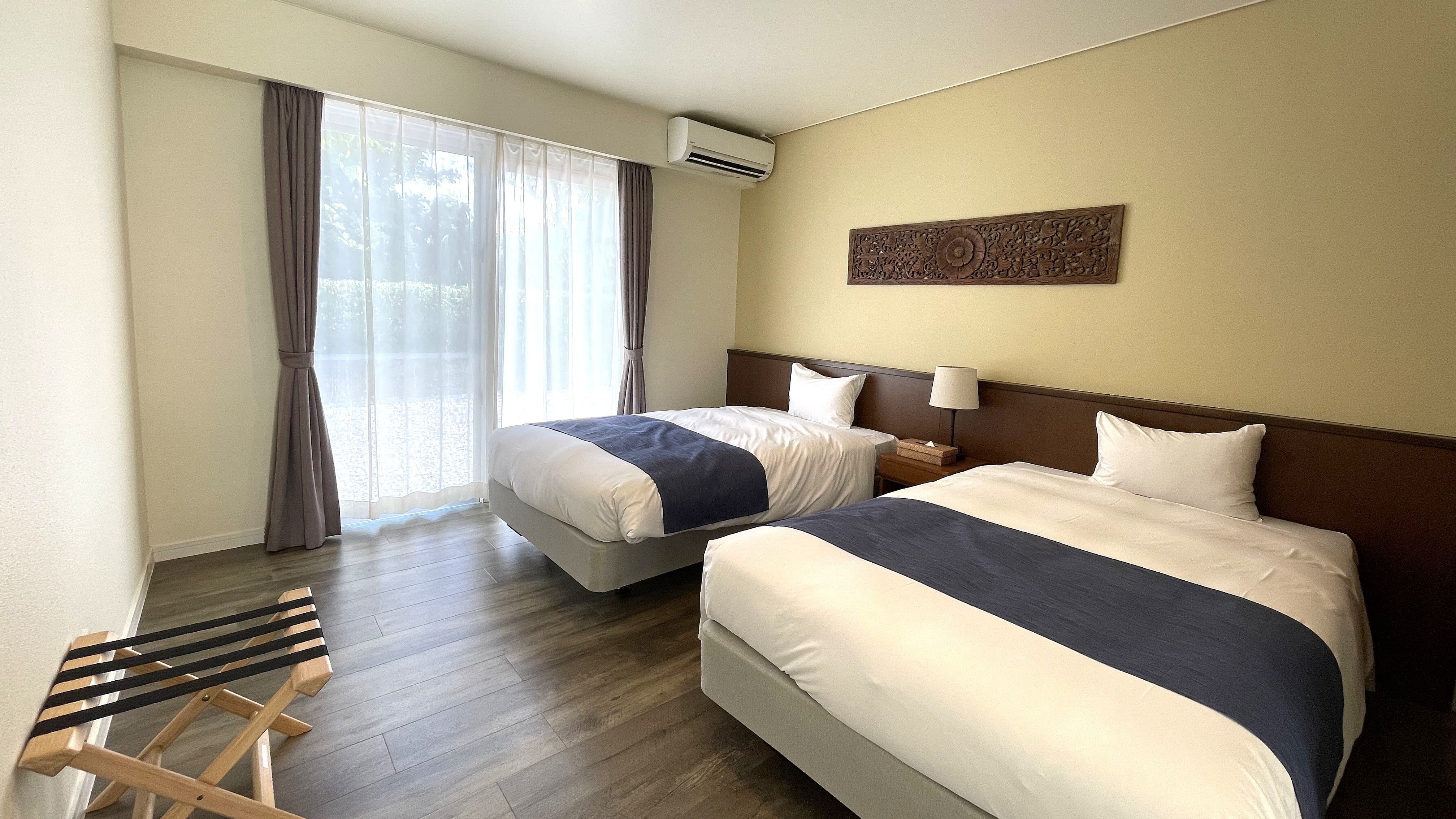 【ORCHID：ベッドルーム】光が差し込む明るい洋室。快適な眠りをサポートする上質なベッド。