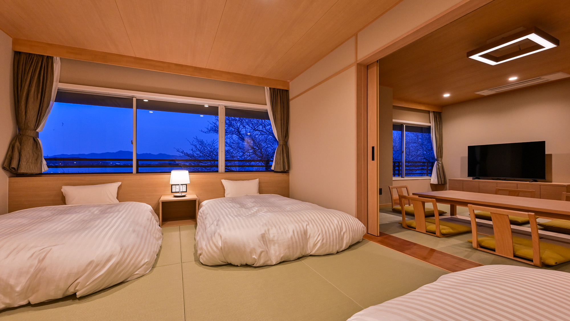 夕暮れのデラックス和洋室。ベッドルームでごゆっくりとお休みください。