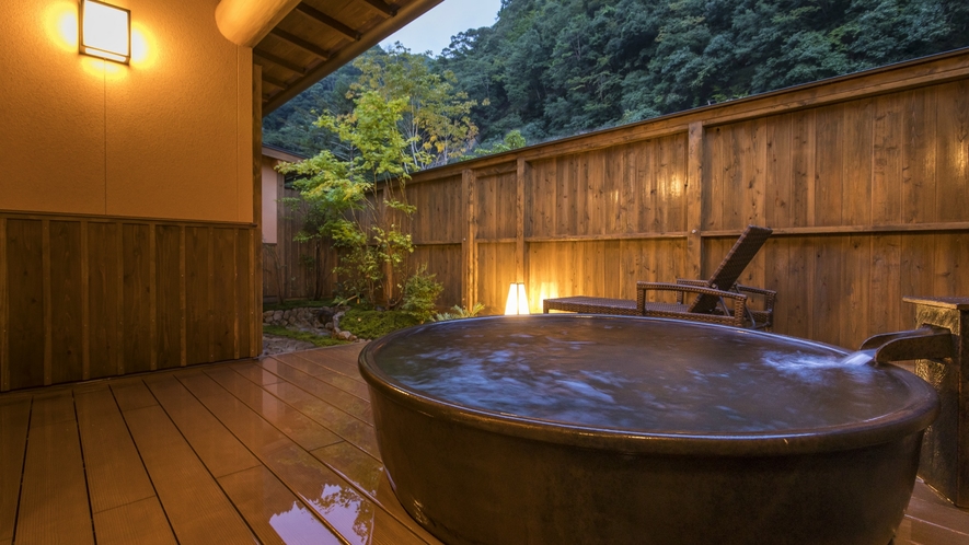 庭の木製デッキには露天風呂をしつらえております。100％源泉かけ流しの極上の湯をプライベート空間で。