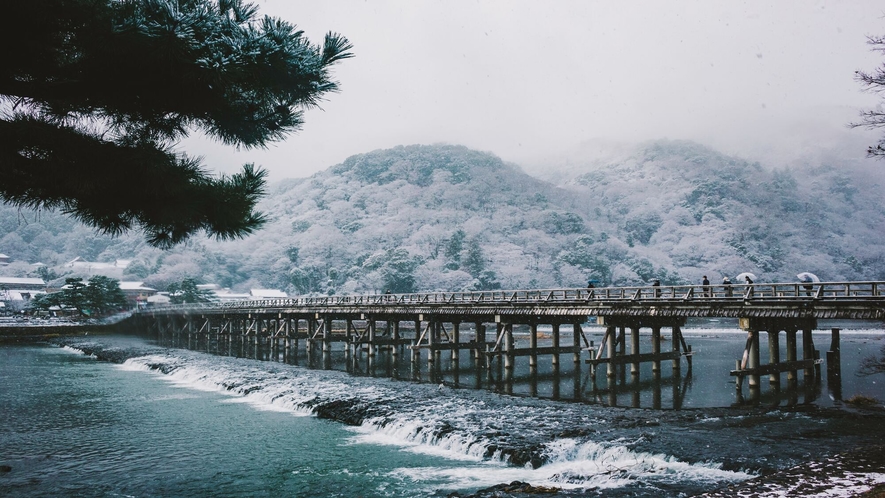 【嵐山・渡月橋】真っ白な嵐山、雪の白さが際立つ山水画のような風景が広がります。