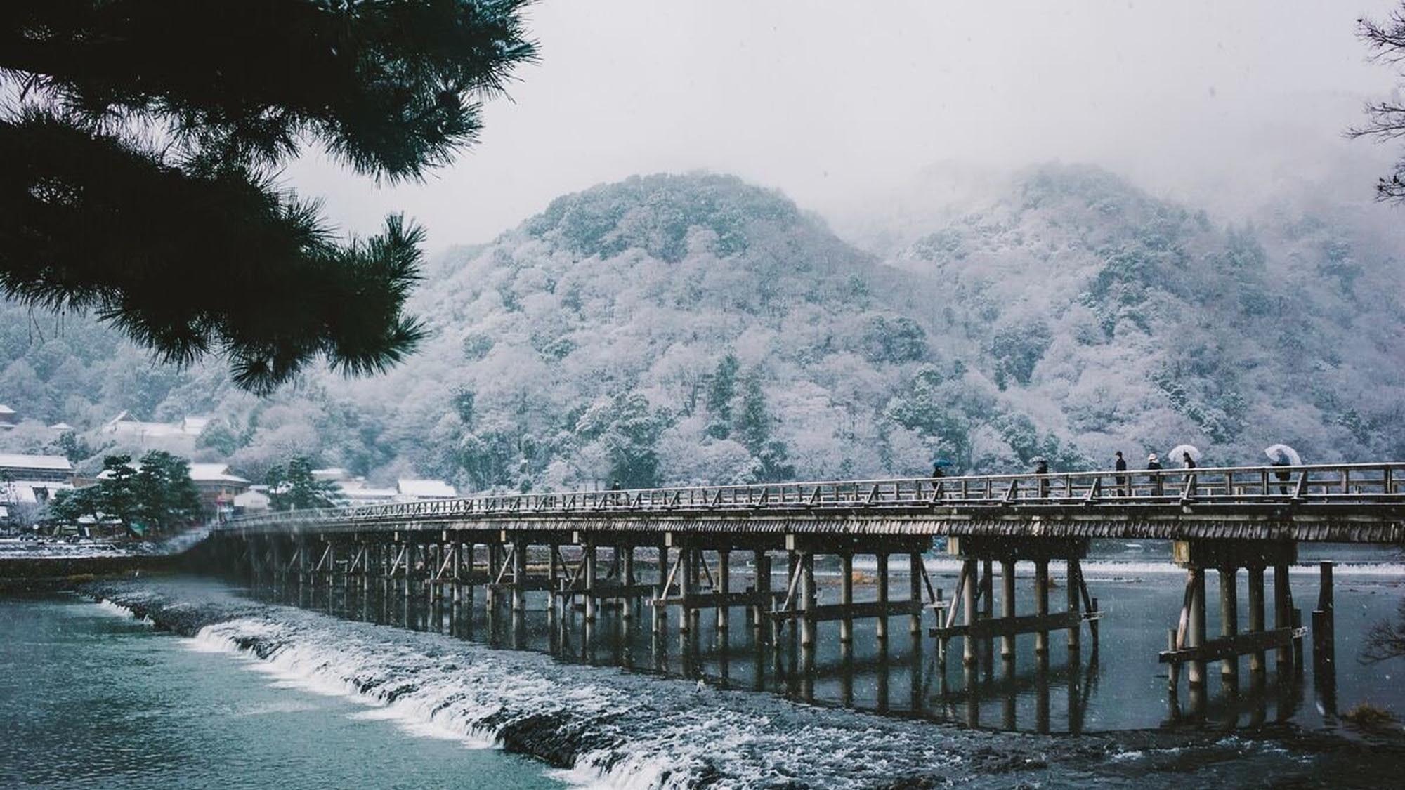 【京都嵐山】真っ白な嵐山、雪の白さが際立つ山水画のような風景が広がる渡月橋。