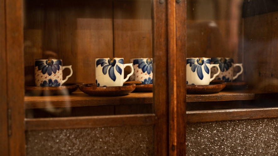 アンティークの食器棚に京焼のカップ