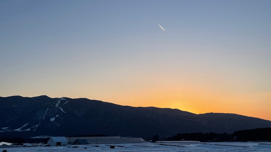 夕景  南アルプスの山々に沈む夕日と飛行機雲