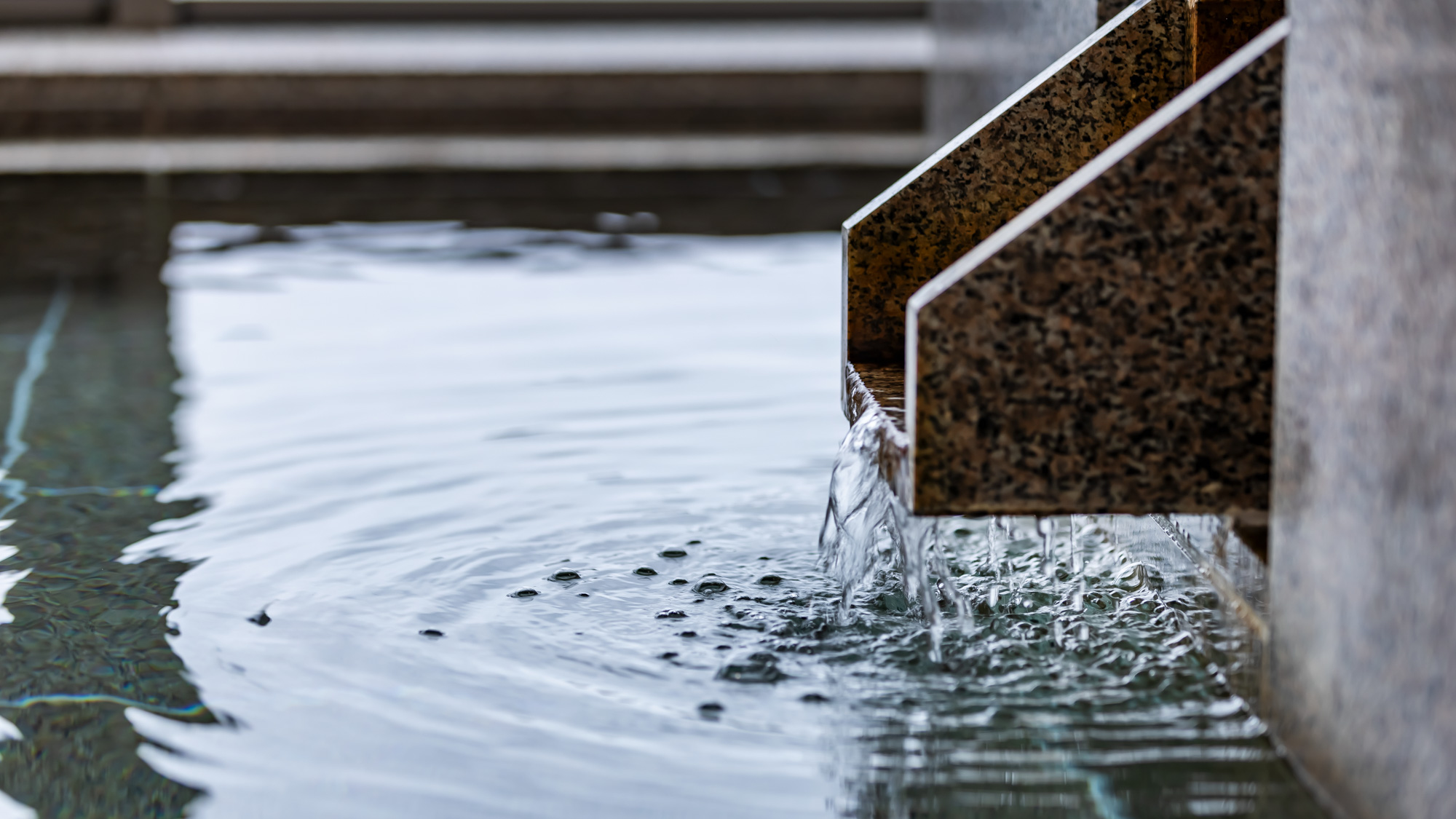 静かに湯が流れ込む大浴場。水面の揺らぎに心癒されながら、ゆったりとしたひとときを。