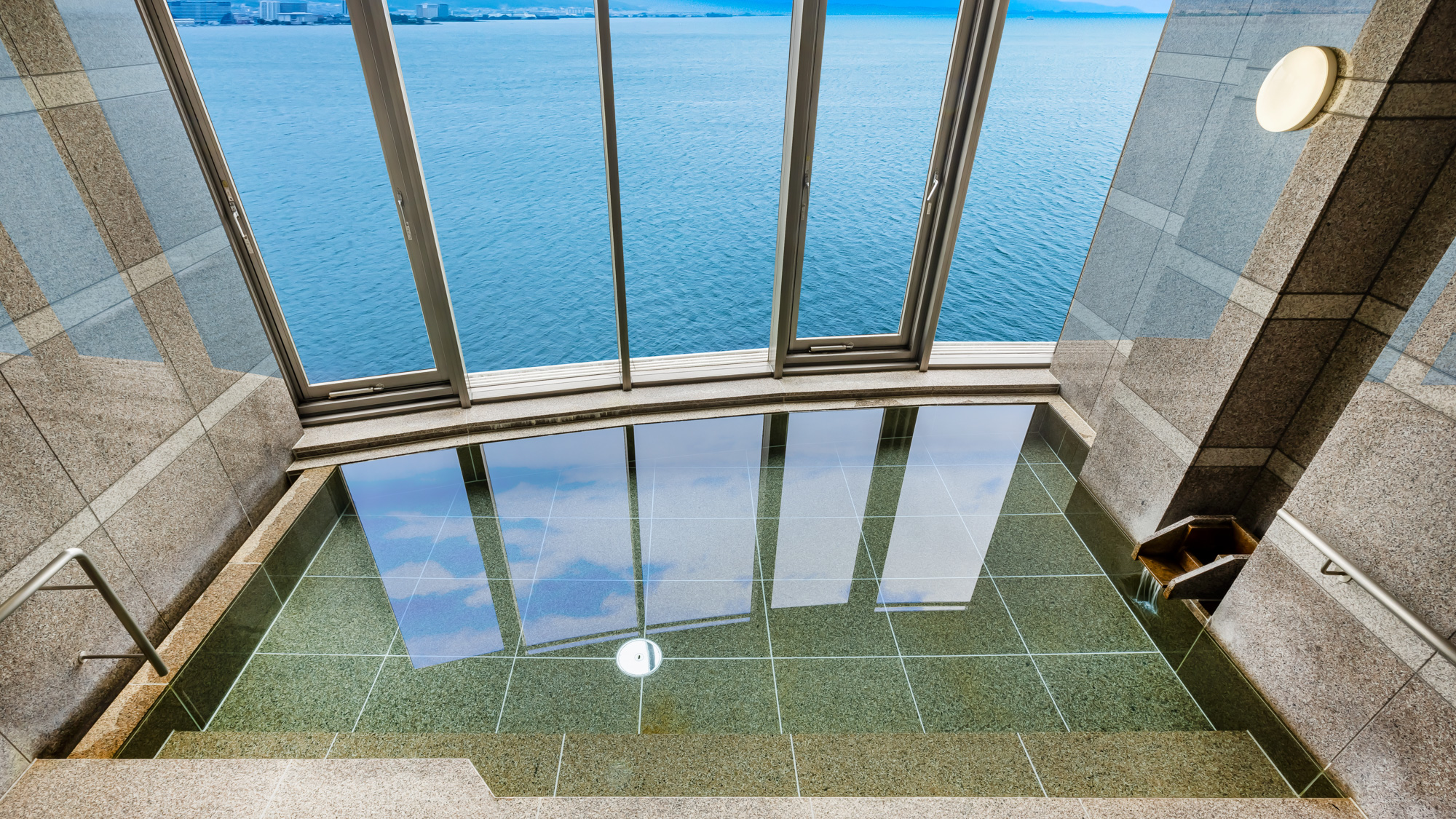 大きな窓の向こうに琵琶湖が広がる展望風呂。水面のきらめきを眺めながらゆったりと。