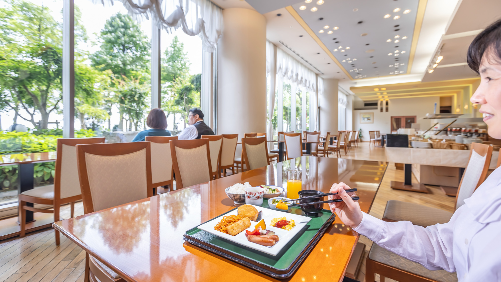 大きな窓から光が差し込むレストランで楽しむ朝食。湖畔の景色を眺めながら。