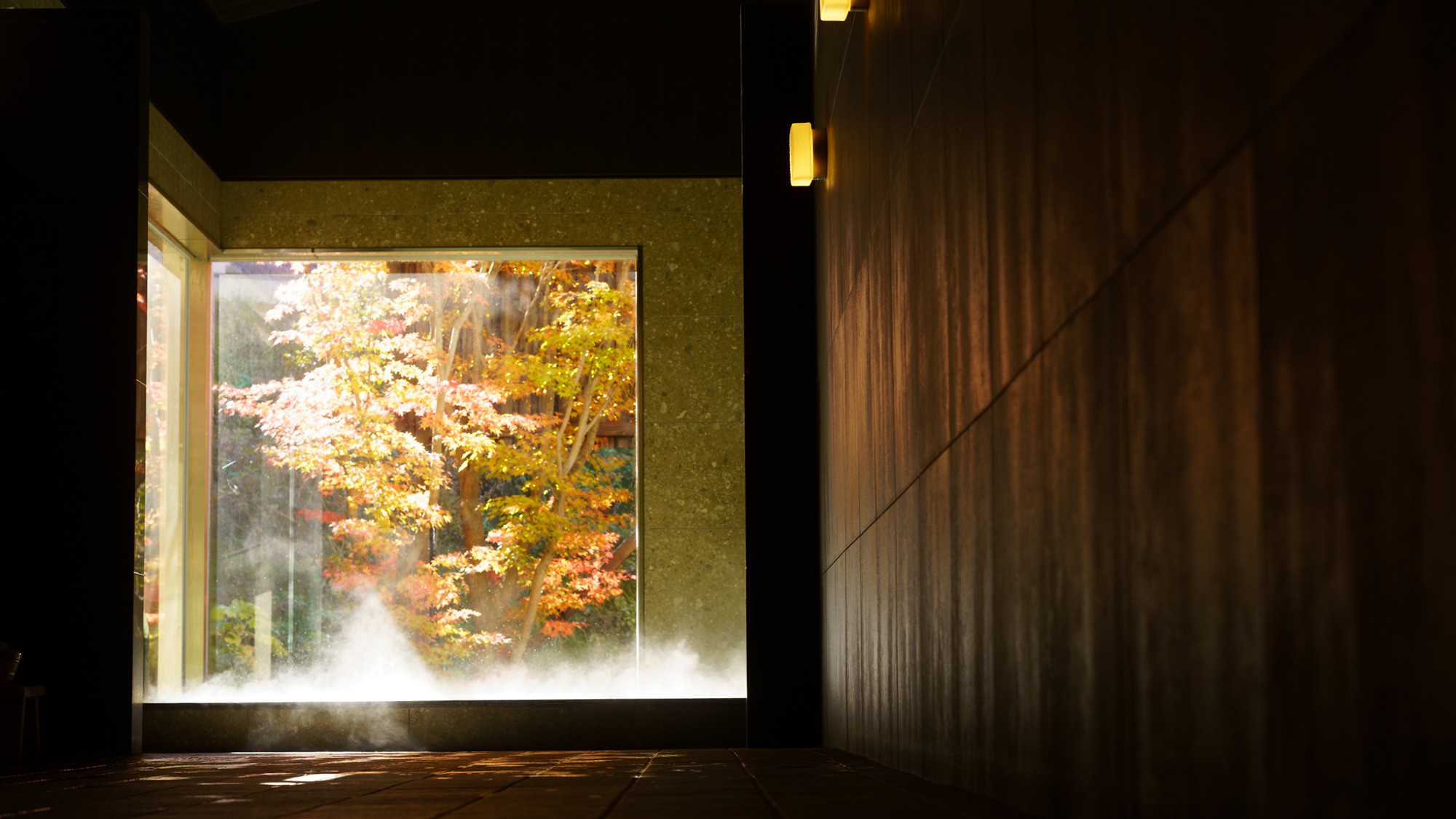 日帰り温泉（ご宿泊様無料）／紅葉の八風温泉／扉の先には、開放的なガラス窓越しに映える鮮やかな紅葉