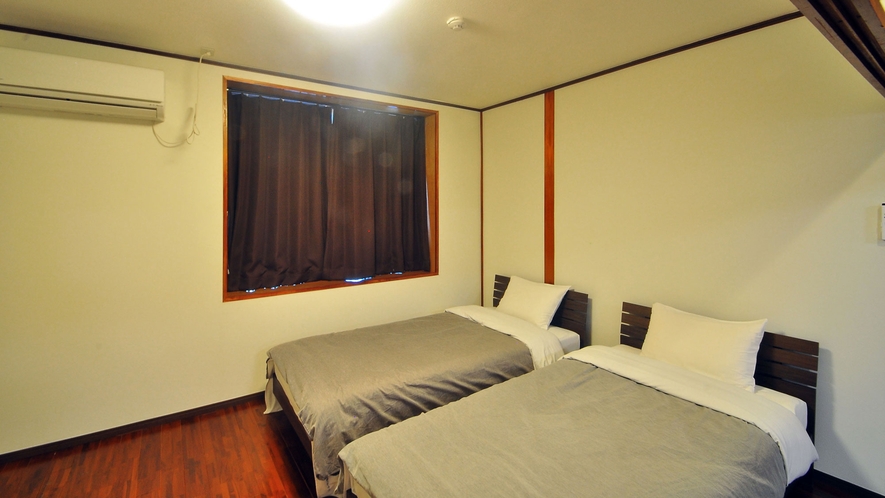 【ツインルーム】シングルベッドが2台あります。仕切りを取り払えばリビングと合わせ、広々とした空間です