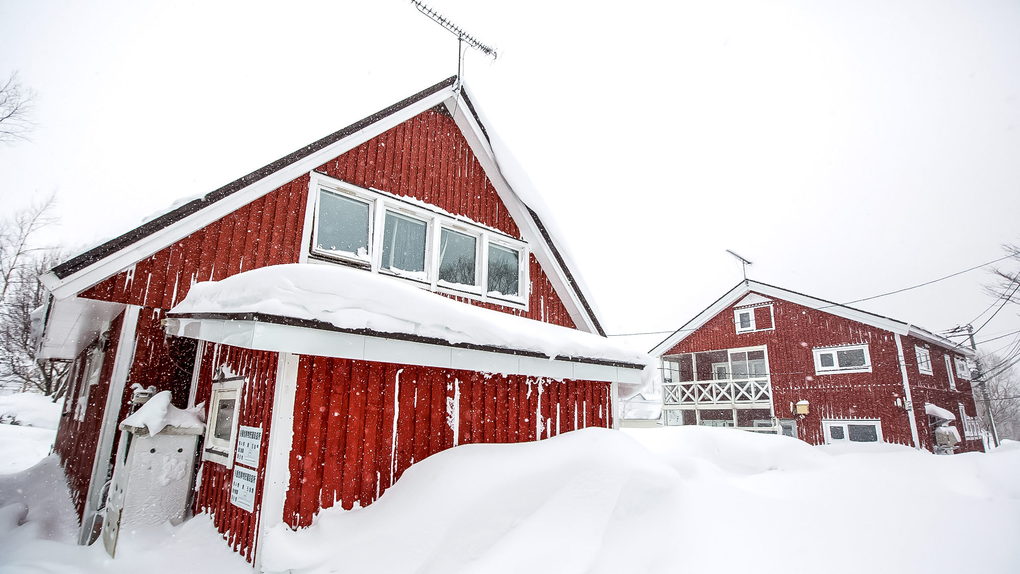 ・＜外観（冬）＞真っ赤な外装のロッジに雪景色が映えます