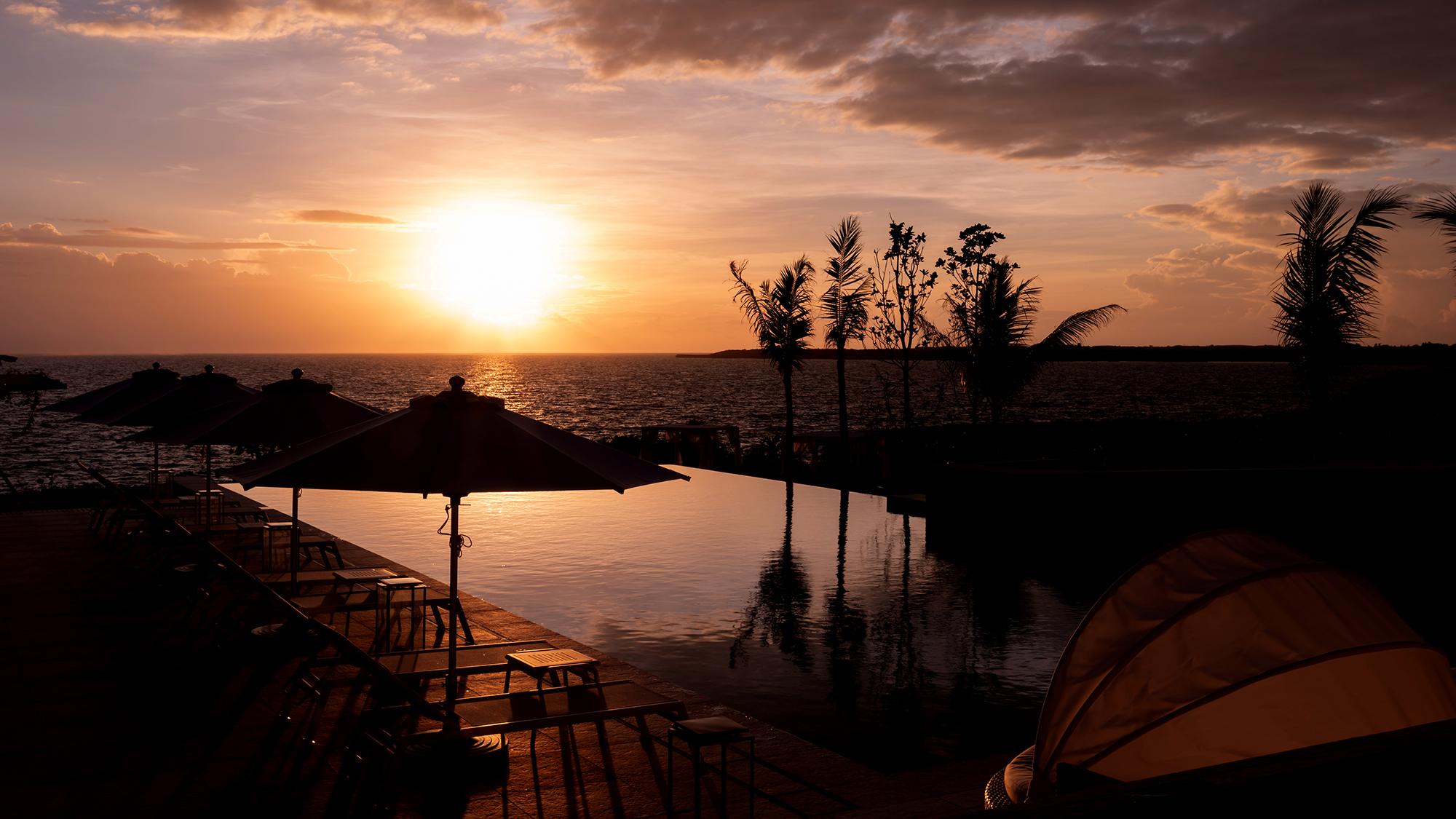 ロビーから眺める夕日は絶景！海に繋がるようなエッジレスプールに沈む夕日を眺めながら休息のひとときを。