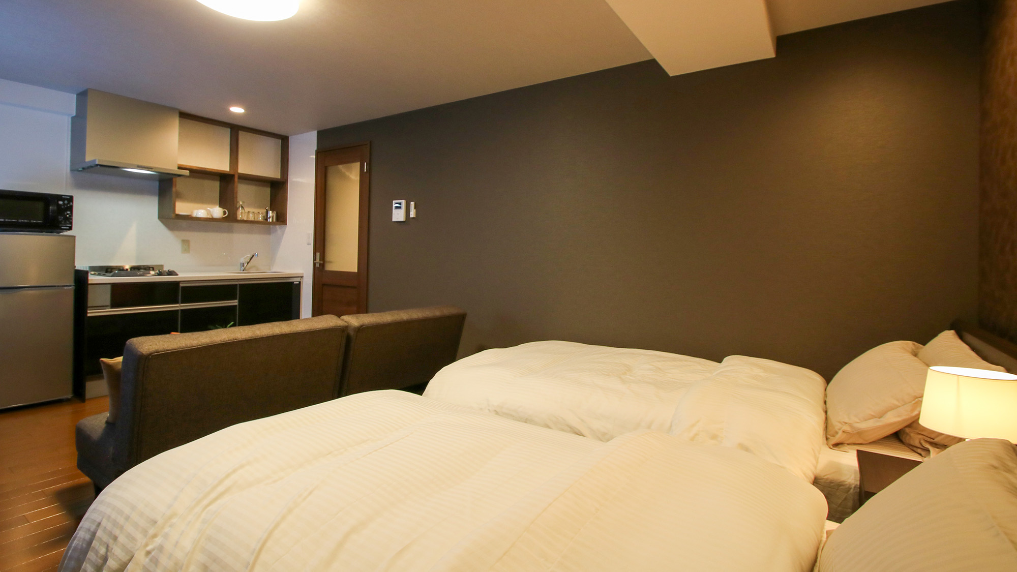 ・【ツインB／ベッド】ベッドのすぐそばにキッチンがあり、室内移動も楽にお過ごしいただけます