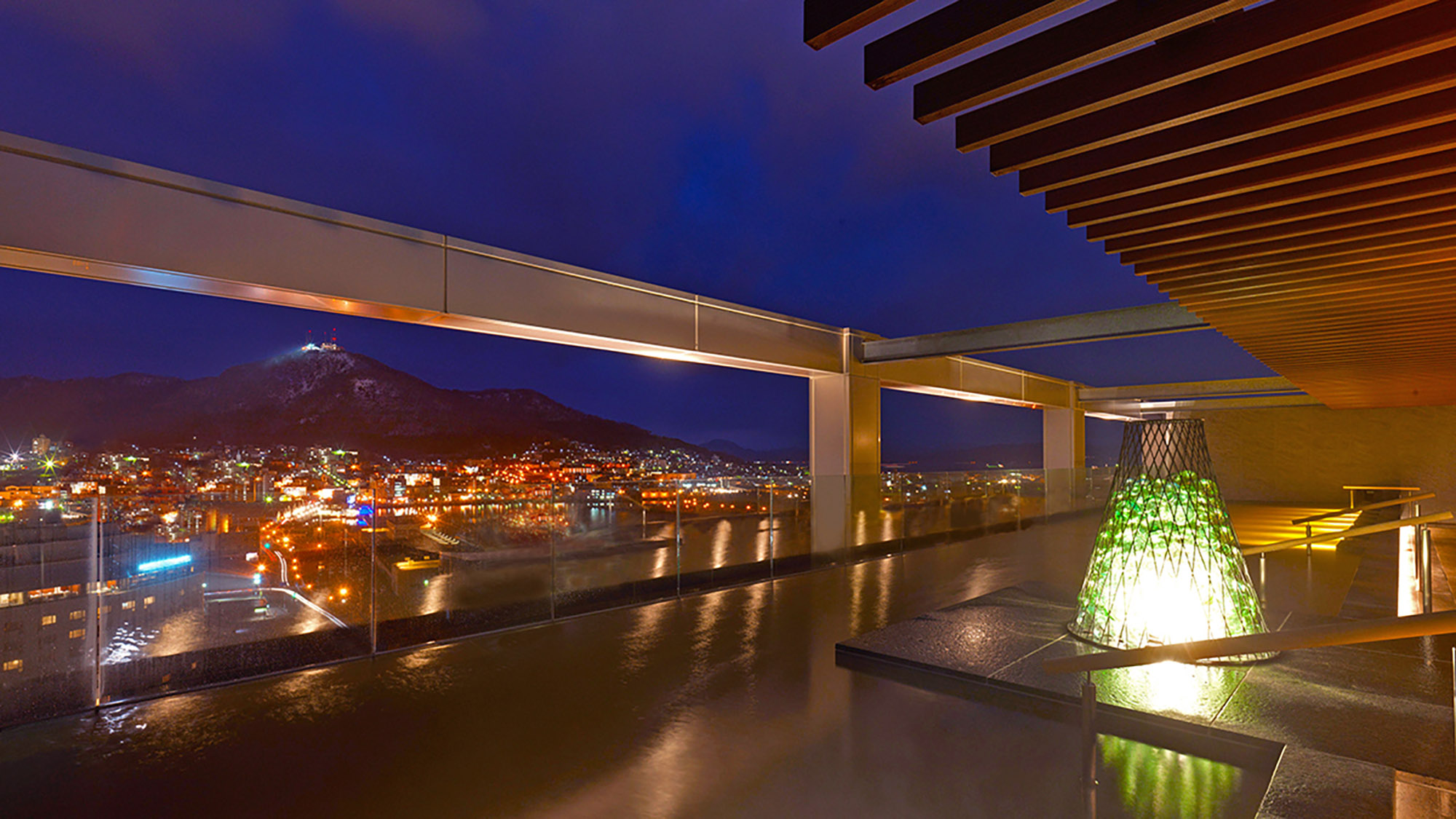 【大浴場】天空露天風呂からは函館山を一望。昼は明るい日差しが差し、夜は幻想的な雰囲気に…。