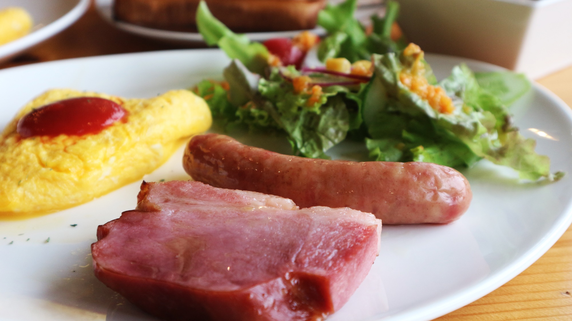 *朝食一例／古川ミートのソーセージに厚切りのベーコン、手作りドレッシングが人気