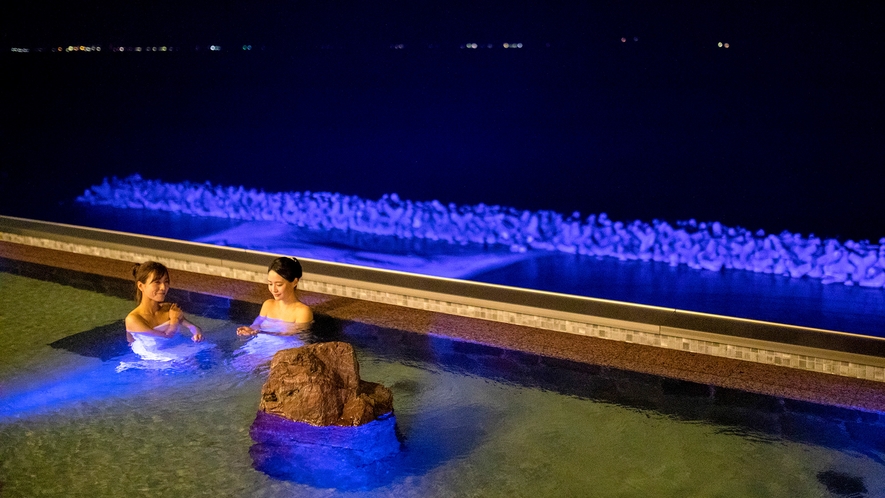 目の前の浜をブルーライトでライトアップ。インフィニティ天空露天風呂の水中照明と水平線の漁火も。