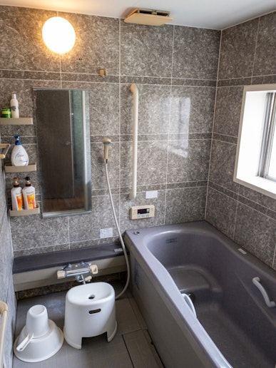 Bathroom with a bathtub, shampoo, conditioner, bod