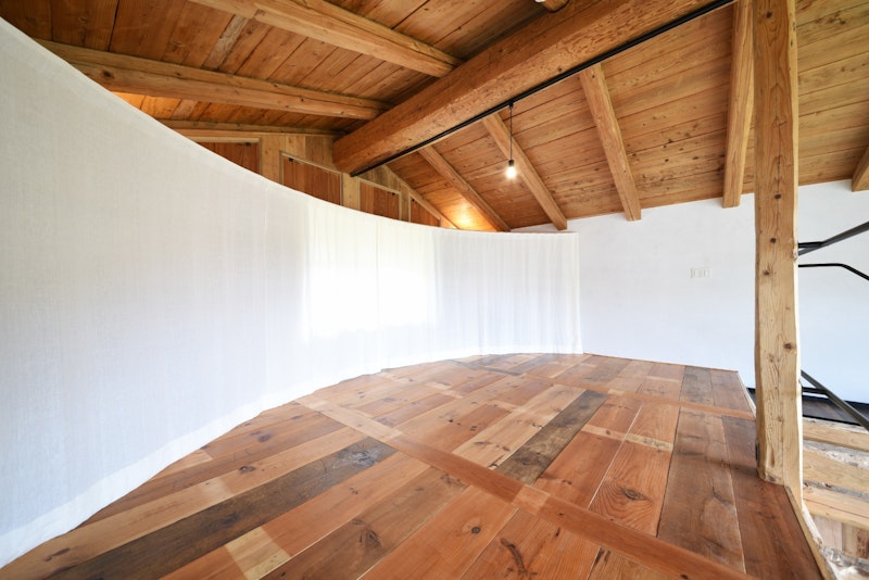 弧を描くカーテンで包まれる寝室