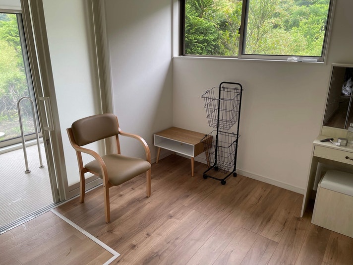 脱衣所の外は谷地でその先の山を望む。