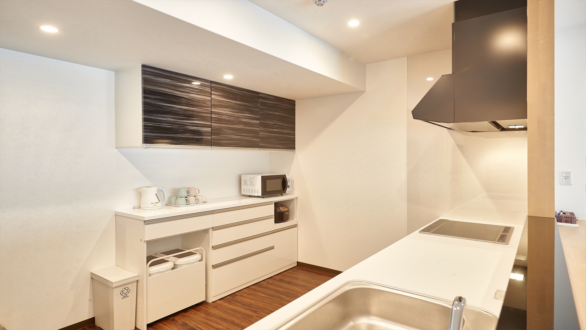 【デラックス2LDKスイート/キッチン】清潔感のあるオールホワイトのキッチン。充実した設備。